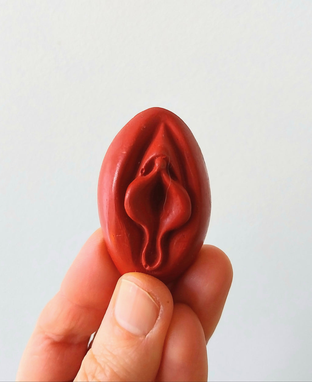 Crayon de subversion en cire végétale et pigments naturels VULVA NATURALIS, en forme de vulve, rouge, vue de face.