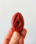 Crayon de subversion en cire végétale et pigments naturels VULVA NATURALIS, en forme de vulve, rouge, vue de face.