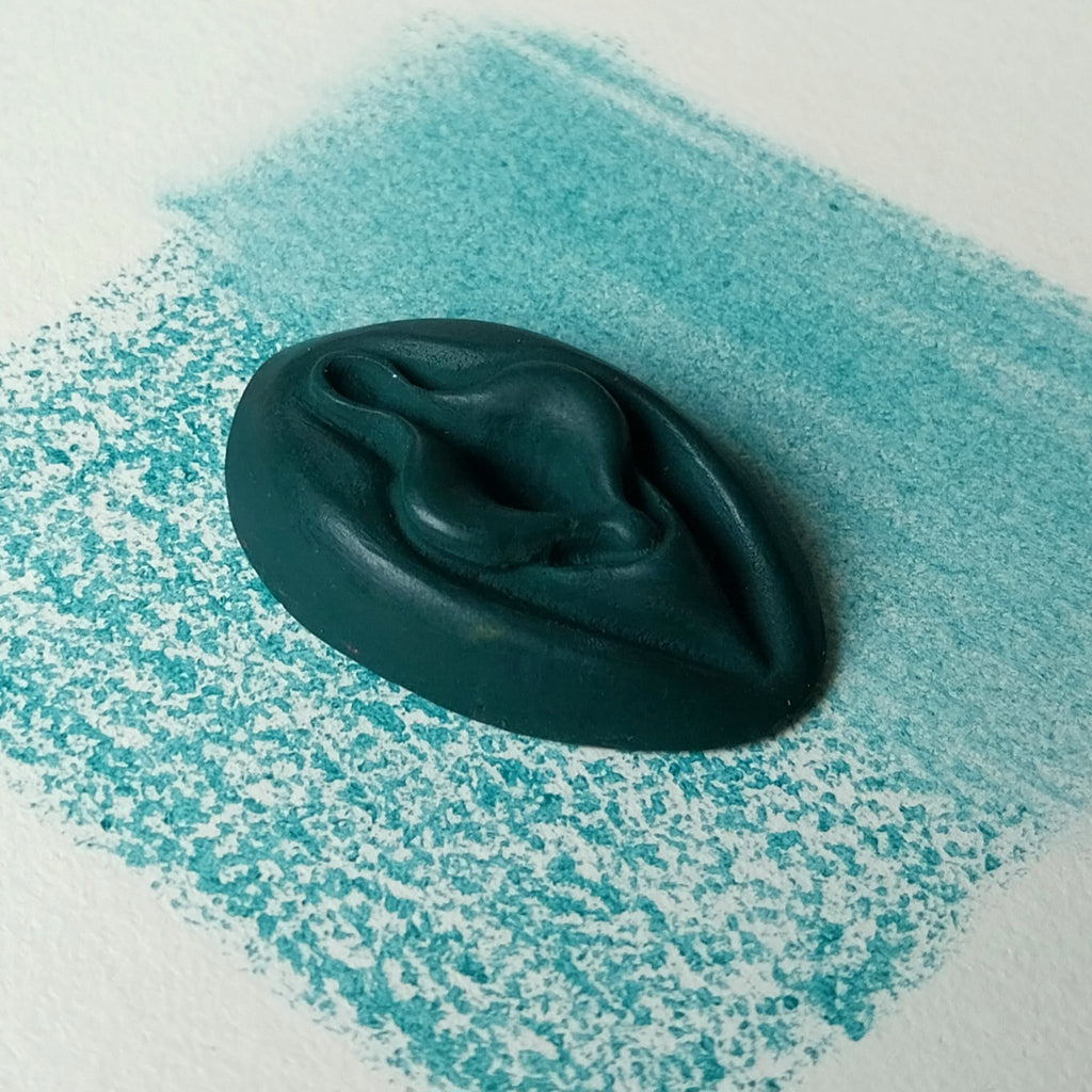 Crayon de subversion VULVA NATURALIS emeraude, vue de profil. Crayon de cire, pastel gras. Dépose de couleur sur une feuille puis estompe au doigt
