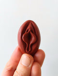 Crayon de subversion en cire végétale et pigments naturels VULVA NATURALIS, en forme de vulve, bordeau, vue de face.