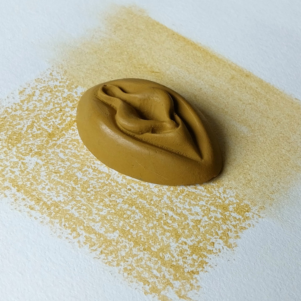 Crayon de subversion VULVA NATURALIS jaune, vue de profil. Crayon de cire, pastel gras. Dépose de couleur sur une feuille puis estompe au doigt