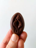 Crayon de subversion en cire végétale et pigments naturels VULVA NATURALIS, en forme de vulve, chocolat, vue de face.